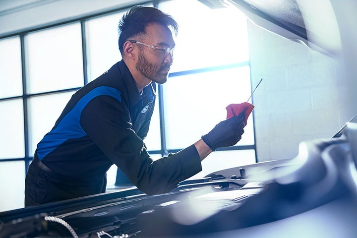 Man wiping oil off of an oil dipstick